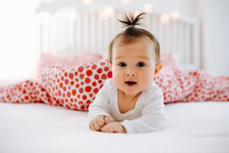 Người mẹ đang nhẹ nhàng thoa kem bôi hăm lên mông bé, tay sạch sẽ